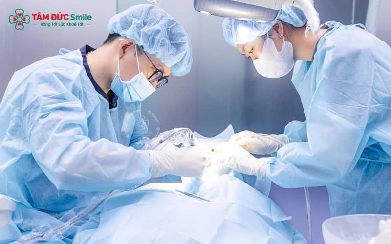 Bác sĩ tại Nha khoa Tâm Đức Smile thực hiện làm sạch mảng bám, xử lý túi nha chu và bôi thuốc kháng viêm giúp trẻ hồi phục nhanh và an toàn